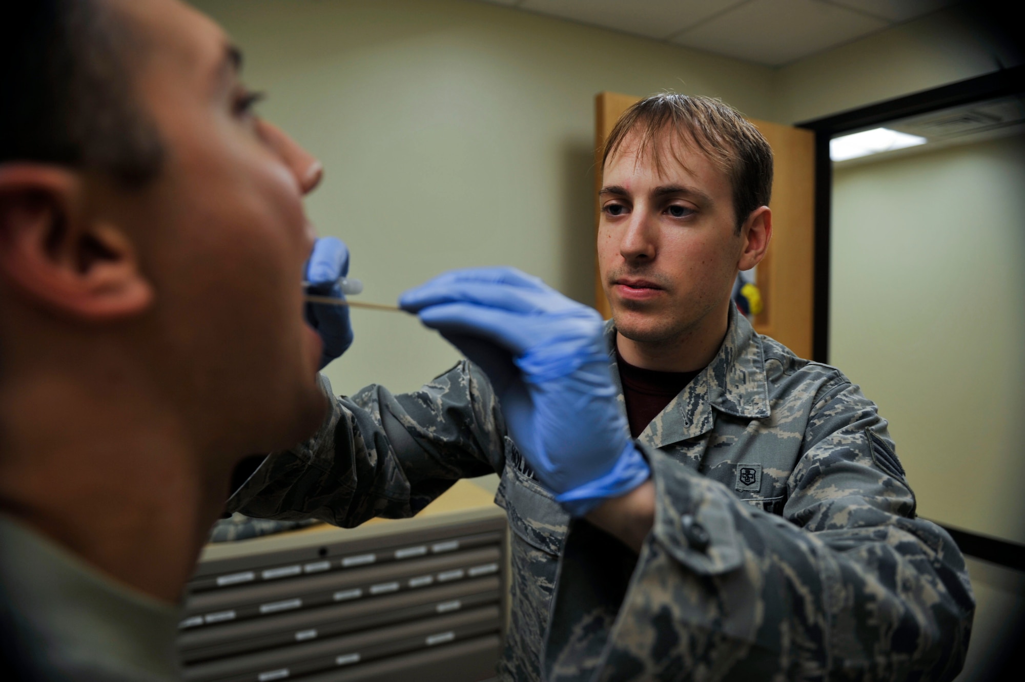 Senior Airman Joseph Holweger, 51st medical operations squadron family health technician, takes a throat swab from an Airman to check for strep throat on Osan Air Base, Republic of Korea, July 11, 2014. Holweger is this week’s Airman Spotlight. (U.S. Air Force photo by Senior Airman David Owsianka)