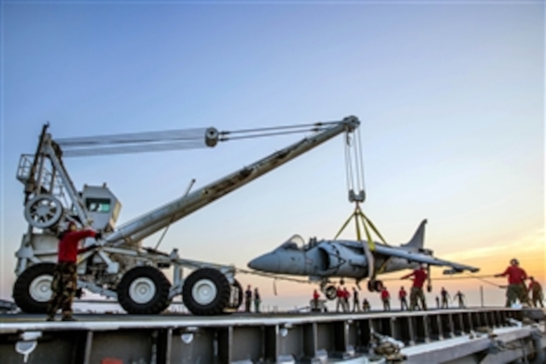 Sailors use a crash crane to practice rigging a damaged aircraft during flight deck drills aboard the amphibious assault ship USS Kearsarge in the Atlantic Ocean, July 13, 2014. The Kearsarge is conducting sea trials. The sailors are assigned to the crash and salvage team.