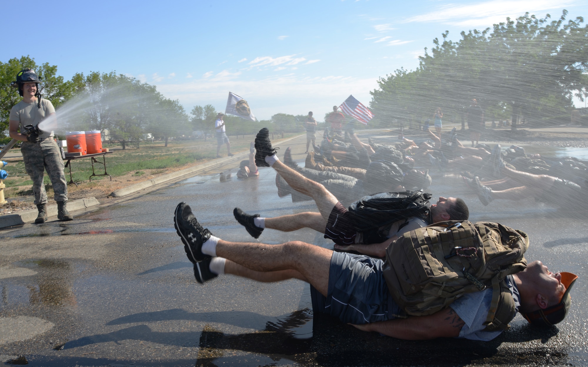 Airmen from the 366th Civil Engineering Squadron fire department use a fire hose to spray members participating in the GORUCK Light Challenge July 12, 2014, at Mountain Home Air Force Base, Idaho. Mountain Home AFB is the first of 18 Air Force bases to test the Team Cohesion Challenge, which will end in November. (U.S. Air Force photo/Senior Airman Benjamin Sutton)