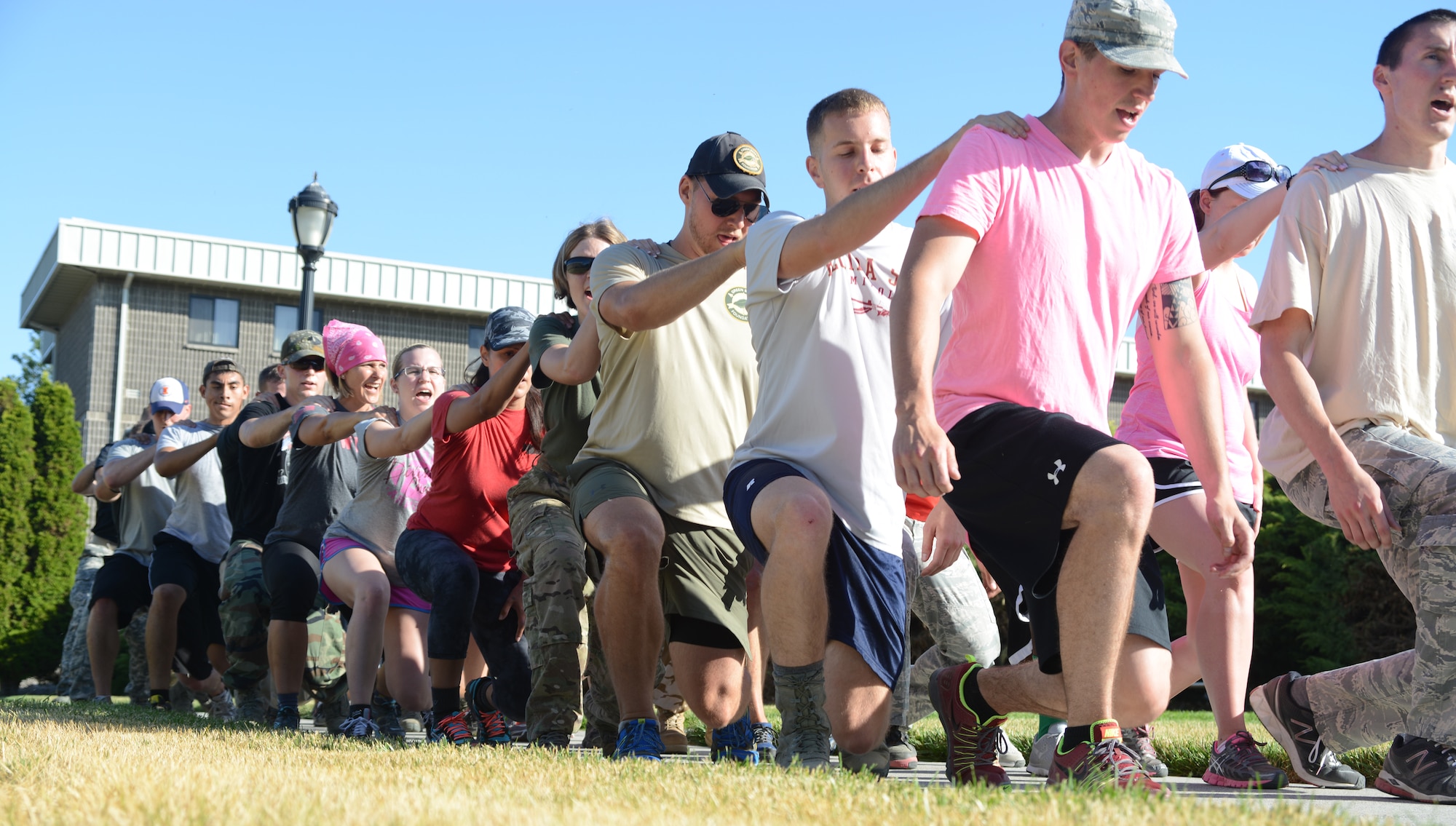 Members perform team lunges as part of the GORUCK Light Challenge July 12, 2014, at Mountain Home Air Force Base, Idaho. The new Air Force pilot program aims to get Airmen, dependents and Department of Defense employees involved in activities challenging them as a team and also encouraging a healthy, resilient lifestyle. (U.S. Air Force photo/Senior Airman Benjamin Sutton)