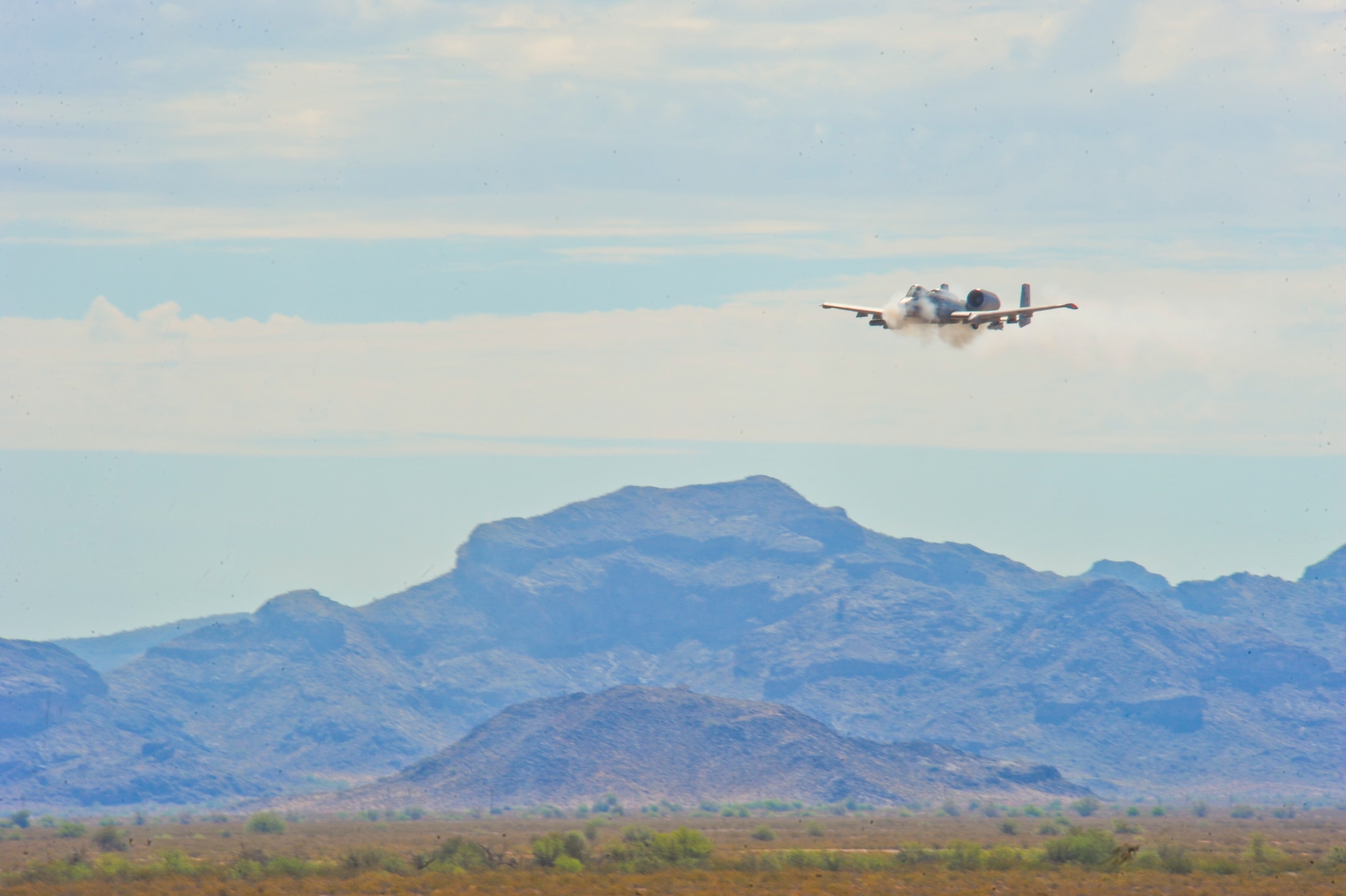 An A-10 Thunderbolt II strafes during the 2014 Hawgsmoke competition July 10, 2014, at the Barry M. Goldwater Range II in Tucson, Ariz. The 2014 Hawgsmoke competition focused on forward firing. The participants competed in high, medium, and low-angle strafes. (U.S. Air Force photo/Airman 1st Class Sivan Veazie)