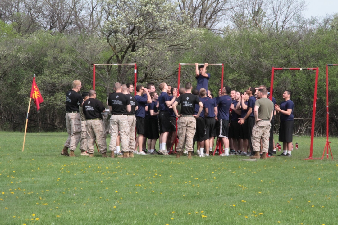 Poolees participate in a friendly competition during an all hands pool function. The poolee hanging from the bar is a male applicant who is demonstrating the flexed arm hang which is only required of the females.