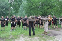 Sgt. Daniel Vallejo from Recruiting Sub-station Fox Valley, Recruiting Station Chicago demonstrates how to adjust a pack before stepping off on a hike during a pool function, July 12.