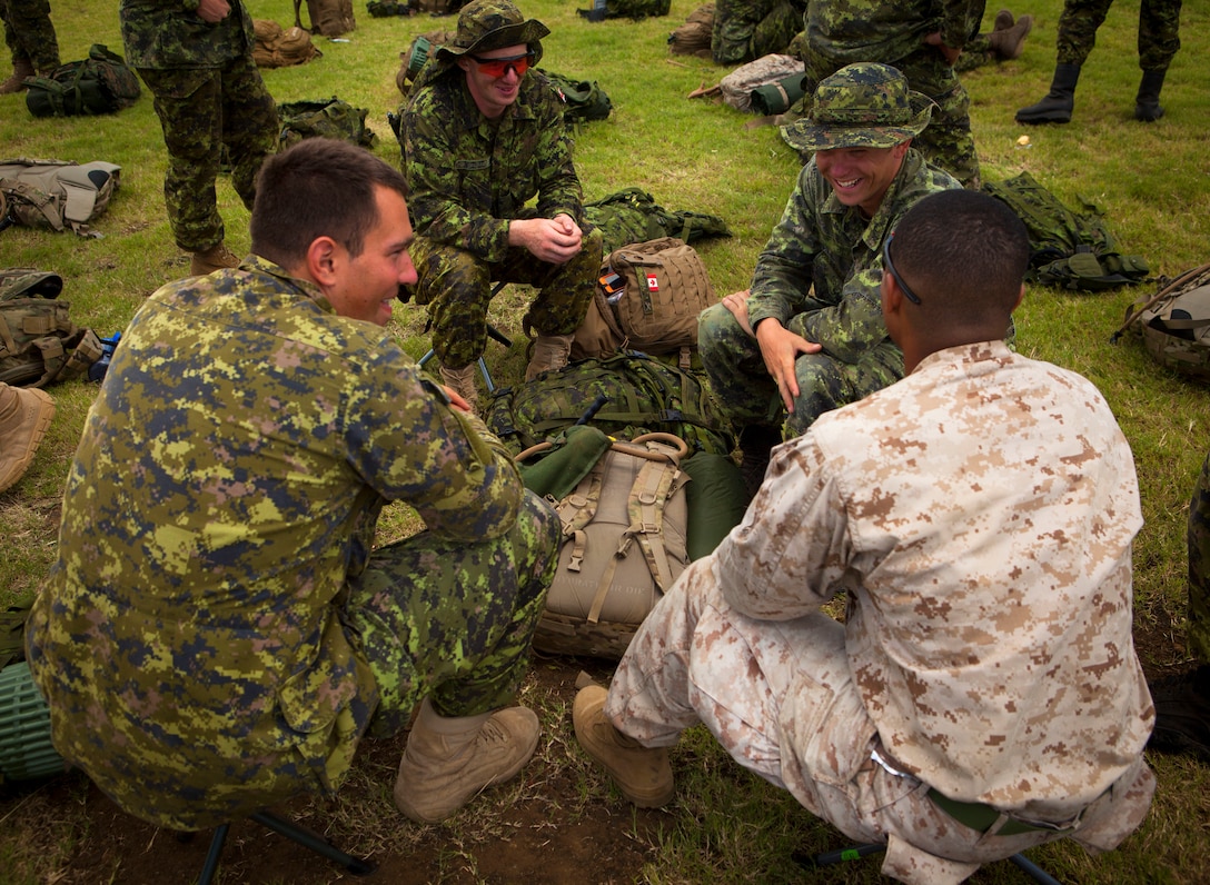 MARINE CORPS BASE HAWAII - Canadian Soldiers with Charlie Company, 3rd Battalion, Princess Patricias Canadian Light Infantry (PPCLI), interact with U.S. Marines during Rim of the Pacific (RIMPAC) Exercise 2014 at Landing Zone Eagle, July 2. Twenty-two nations, 49 ships, 6 submarines, more than 200 aircraft and 25,000 personnel are participating in RIMPAC from June 26 to Aug. 1, in and around the Hawaiian Islands and Southern California. The world's largest international maritime exercise, RIMPAC provides a unique training opportunity that helps participants foster and sustain the cooperative relationships that are critical to ensuring the safety of sea lanes and security on the world's oceans. RIMPAC 2014 is the 24th exercise in the series that began in 1971.  (U.S. Marine Corps photo by Lance Cpl. Aaron S. Patterson/Released)