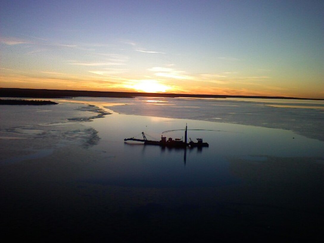 A tugboat, used during dredging operations at John Martin Dam & Reservoir in southeastern Colorado, sits on the water at sunset. Photo by Tony V. Urquidez, Nov. 24, 2008.