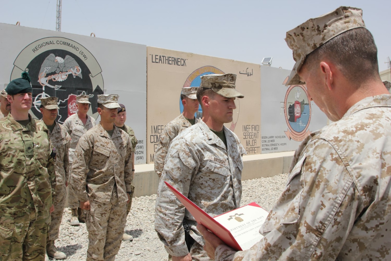U.S. Marine 1st Lt. Joshua Bridges, a native of Morganton, N.C., and assessments and plans officer, Regional Command (Southwest), stands at attention while Maj. Bob McCarthy, reads an award citation during a ceremony aboard Camp Leatherneck, Helmand province, Afghanistan, July 13, 2014. Bridges deployed to Helmand province during Jan. 2014 and was vital to RC(SW) planning efforts during the 2014 Afghan presidential elections and the upcoming transition of full security responsibility to the Afghan National Security Forces in the region by the end of 2014.