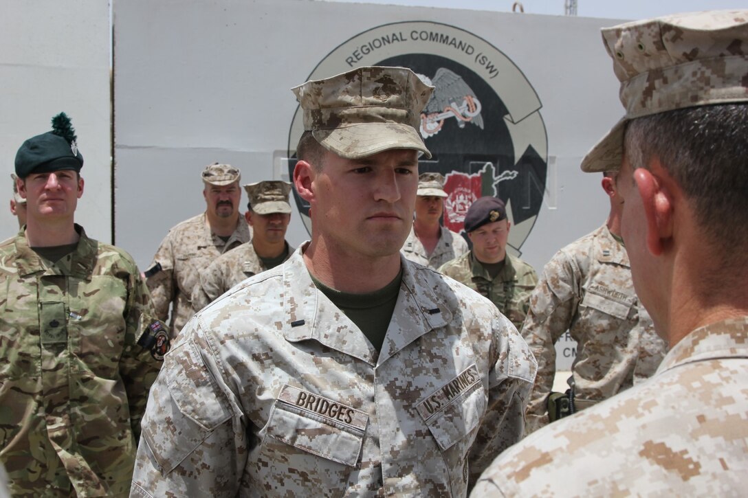 U.S. Marine 1st Lt. Joshua Bridges, a native of Morganton, N.C., and assessments and plans officer, Regional Command (Southwest) stands at attention while Maj. Bob McCarthy, reads an award citation during a ceremony aboard Camp Leatherneck, Helmand province, Afghanistan, July 13, 2014. Bridges deployed to Helmand province during Jan. 2014 and was vital to RC(SW) planning efforts during the 2014 Afghan presidential elections and the upcoming transition of full security responsibility to the Afghan National Security Forces in the region by the end of 2014.