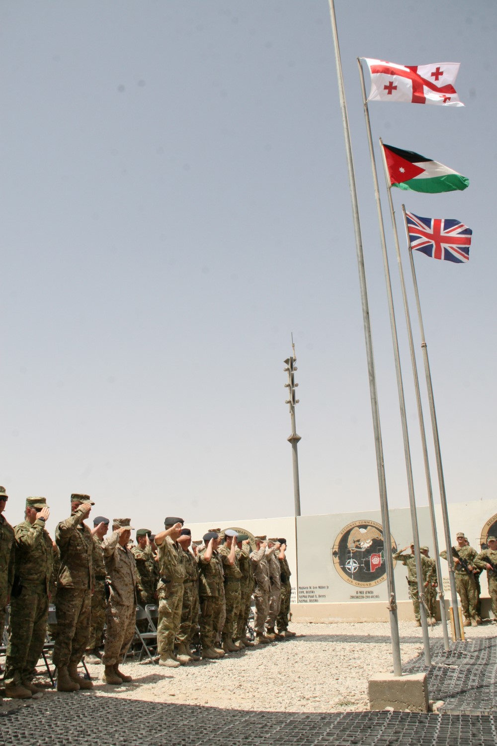 Service members serving with Regional Command (Southwest) salute as the Republic of Georgia's national anthem plays during a ceremony aboard Camp Leatherneck, Helmand province, Afghanistan, July 15, 2014. The ceremony marked the end of mission for the Georgian army serving with RC(SW).