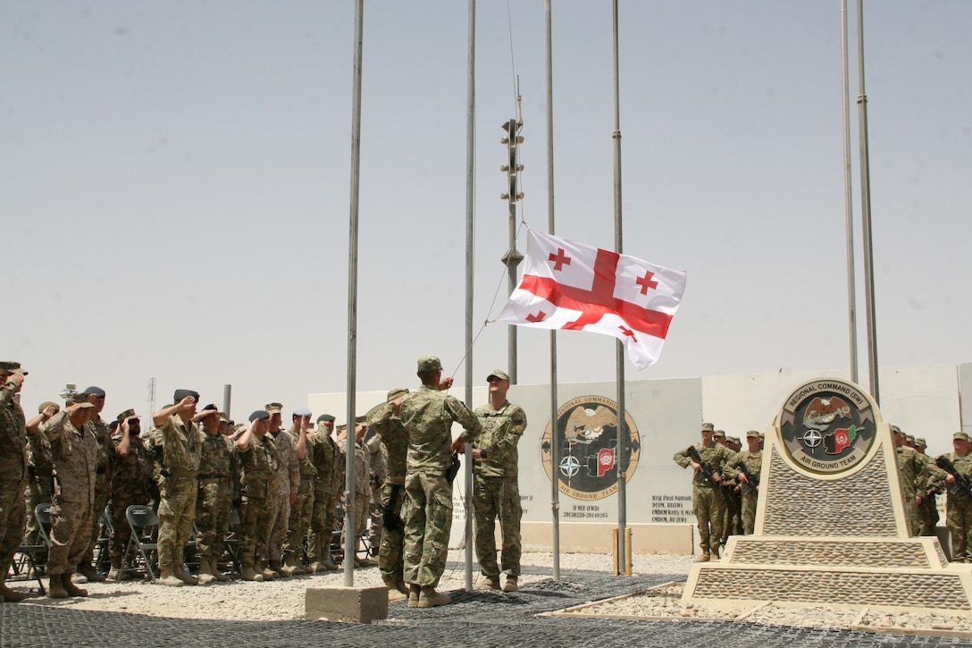 Soldiers with the Republic of Georgia lower their flag during a ceremony aboard Camp Leatherneck, Helmand province, Afghanistan, July 15, 2014. The ceremony marked the end of mission for the Georgian army serving with Regional Command (Southwest).