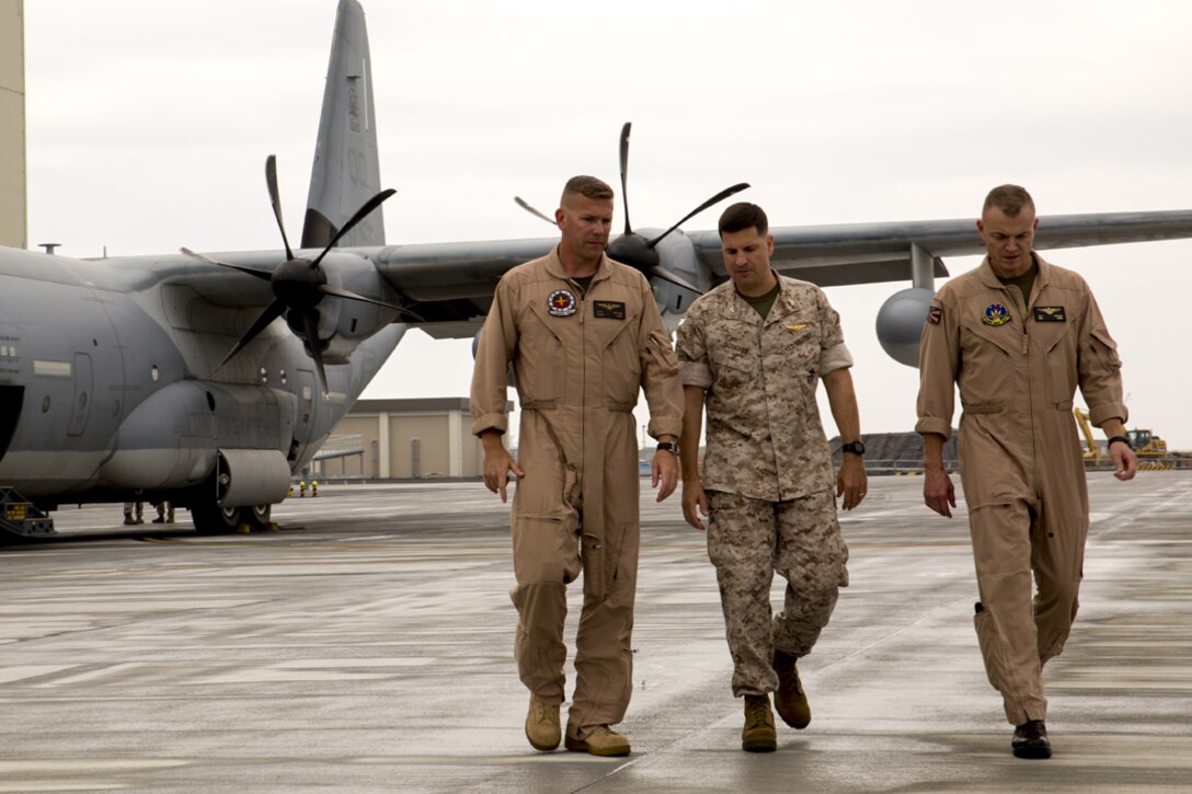 Lt. Col. Matthew W. Stover, commanding officer of Marine Aerial Refueler Transport Squadron 152, left, walks with Col. Robert V. Boucher, commanding officer of Marine Corps Air Station Iwakuni, Japan, middle, and Col. Hunter H. Hobson, commanding officer of Marine Aircraft Group 12 upon arriving at MCAS Iwakuni, July 15, 2014.Upon the KC-130J Super Hercules’ touchdown, administrative control of the squadron effectively changed from MCAS Futenma’s, based out of Okinawa, Japan, Marine Aircraft Group-36 to MAG-12 on Iwakuni. VMGR-152 will remain under operational control of III Marine Expeditionary Force in Okinawa, but MAG-12 will be in charge of providing the squadron with all the gear and supplies necessary in carrying out their missions.