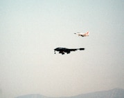 An F-16B Fighting Falcon accompanies the first ever B-2 Spirit to take flight July 17, 1989, over California. The flight took place from the Northrop Grumman production facility in Palmdale, California to Edwards Air Force Base, California where the B-2 would remain in the testing phase until 1993, when the first operational aircraft was delivered to Whiteman AFB, Missouri. (Defense Imagery Management Operations Center photo/Released)