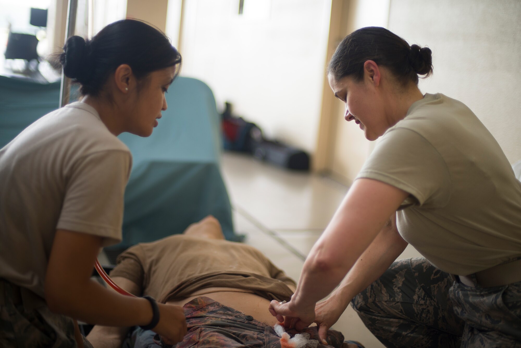 A member of the 374th Medical Group treats a simulated victim during self-aid and buddy care training at Yokota Air Base, Japan, July 16, 2014. SABC skills are taught to all Airmen to ensure they are able to provide basic life and limb-saving techniques on themselves and other injured personnel until medical personnel are available to continue care. (U.S. Air Force photo by Staff Sgt. Chad C. Strohmeyer/Released)