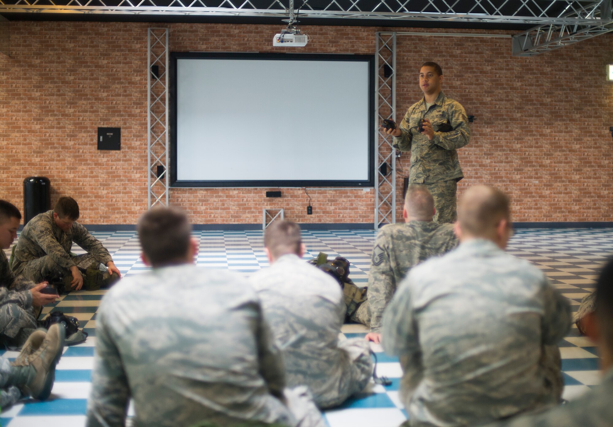 Staff Sgt. Synard Bert, 374th Maintenance Squadron, demonstrates the proper removal of filters on an M-50 mask during ability to survive and operate training at Yokota Air Base, Japan, July 16, 2014. The training reacquaints Airmen with valuable skills needed during a contingency. (U.S. Air Force photo by Staff Sgt. Chad C. Strohmeyer/Released)