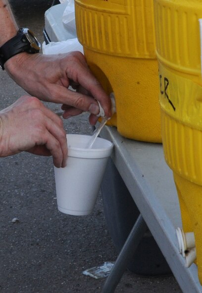 A participant fills their cup with water after the Freedom 5K fun run on Barksdale Air Force Base, La., July 11, 2014. Hydrating after physical activities is important to avoid heat-related injuries, such as heat stress, heat exhaustion and heatstroke. (U.S. Air Force photo/Senior Airman Kristin High)