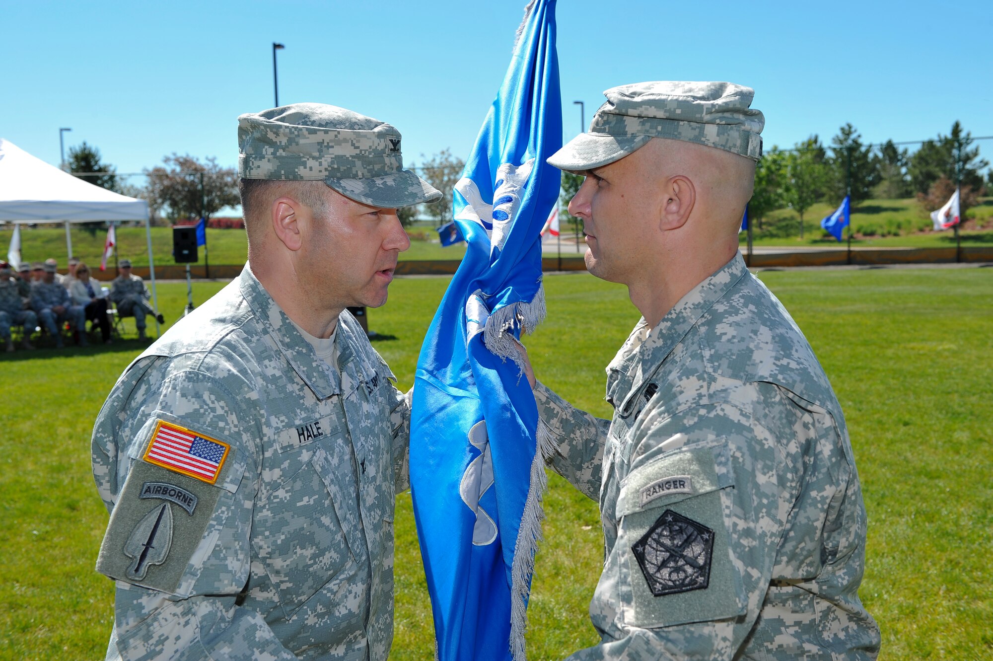 Col. Anthony Hale, 704th Military Intelligence Brigade commander, left, presents the 743rd Military intelligence Battalion guidon to Lt. Col. Andrew Pelka, 743rd MI Battalion commander, signifying his assumption of command June 19, 2014, at the softball fields on Buckley Air Force Base, Colo. During the ceremony, Pelka assumed command from Lt. Col. Gary Hausman after two years of service to the unit. (U.S. Air Force photo by Senior Airman Phillip Houk/Released)