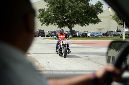 Dale Owens, 12th Flying Training Wing, rides off base on his motorcycle June 24, from Joint Base San Antonio-Randolph. Proper safety gear such as a Department of Transportation approved helmet, pants made of thick material, a reflective vest and protective footwear ensure the riders safety, thus making them clearly visible to other drivers. (U.S. Air Force photo by Johnny Saldivar) 