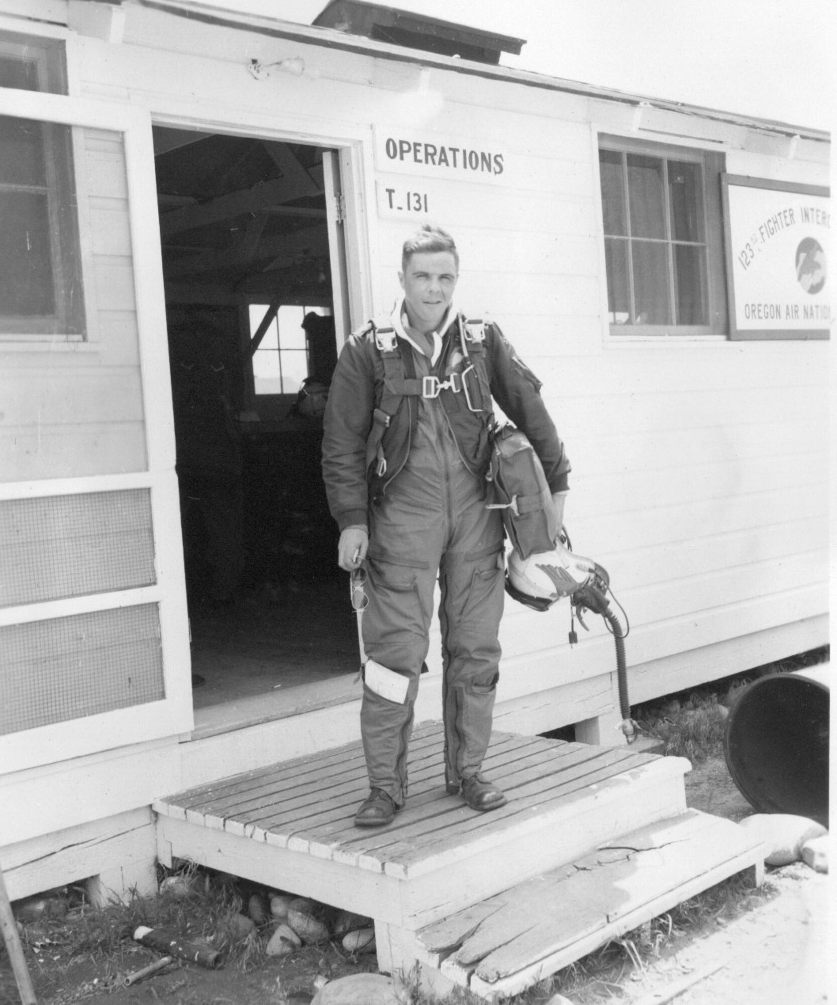 An Oregon ANG F-86 Sabre jet fighter pilot steps, ready to fly, on the doorstep of 123nd Fighter-Interceptor Squadron Operations at Gowen Field, Idaho,  June 17, 1954 (Courtesy 142FW History Archives)