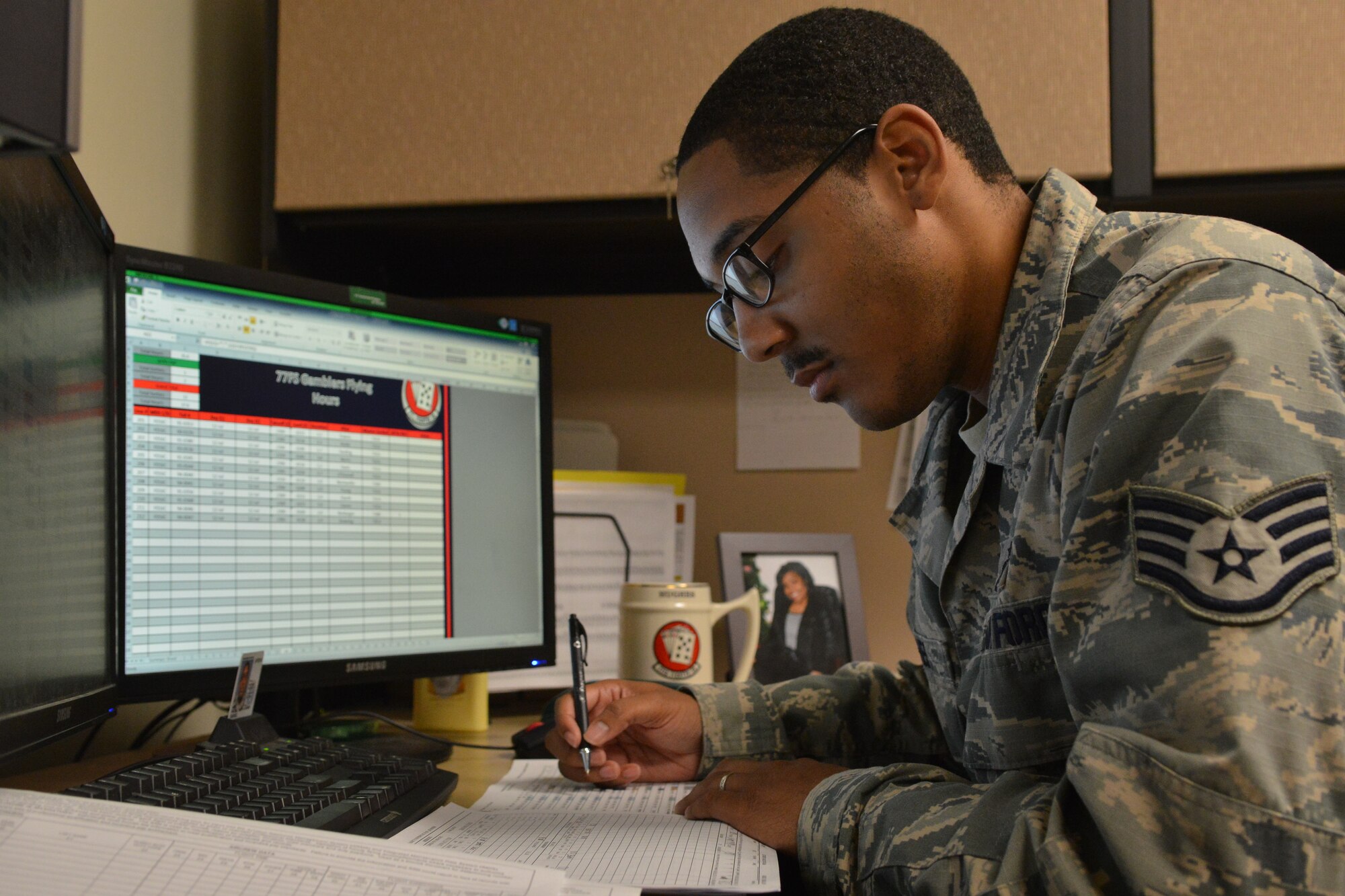 U.S. Air Force Staff Sgt. Manuel Hughes, 77th Fighter Squadron aviation resource manager, reads over a list of the flying hours for the squadron at Shaw Air Force Base, S.C., July 16, 2014. The $95 million Flying Hours Program determines how to allocate training at the 20th Fighter Wing. (U.S. Air Force photo by Senior Airman Ashley L. Gardner/Released) 