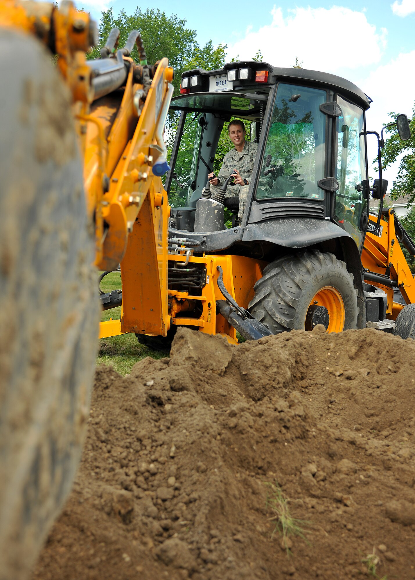 Airman 1st Class Dylan Harrison, 319th Civil Engineer Squadron pavement and equipment operator, digs into the dirt with a backhoe on July 15, 2014, on Grand Forks Air Force Base, N.D. The Las Vegas, Nev., native was named Warrior of the Week for the third week of July, 2014. (U.S. Air Force photo/Senior Airman Xavier Navarro)