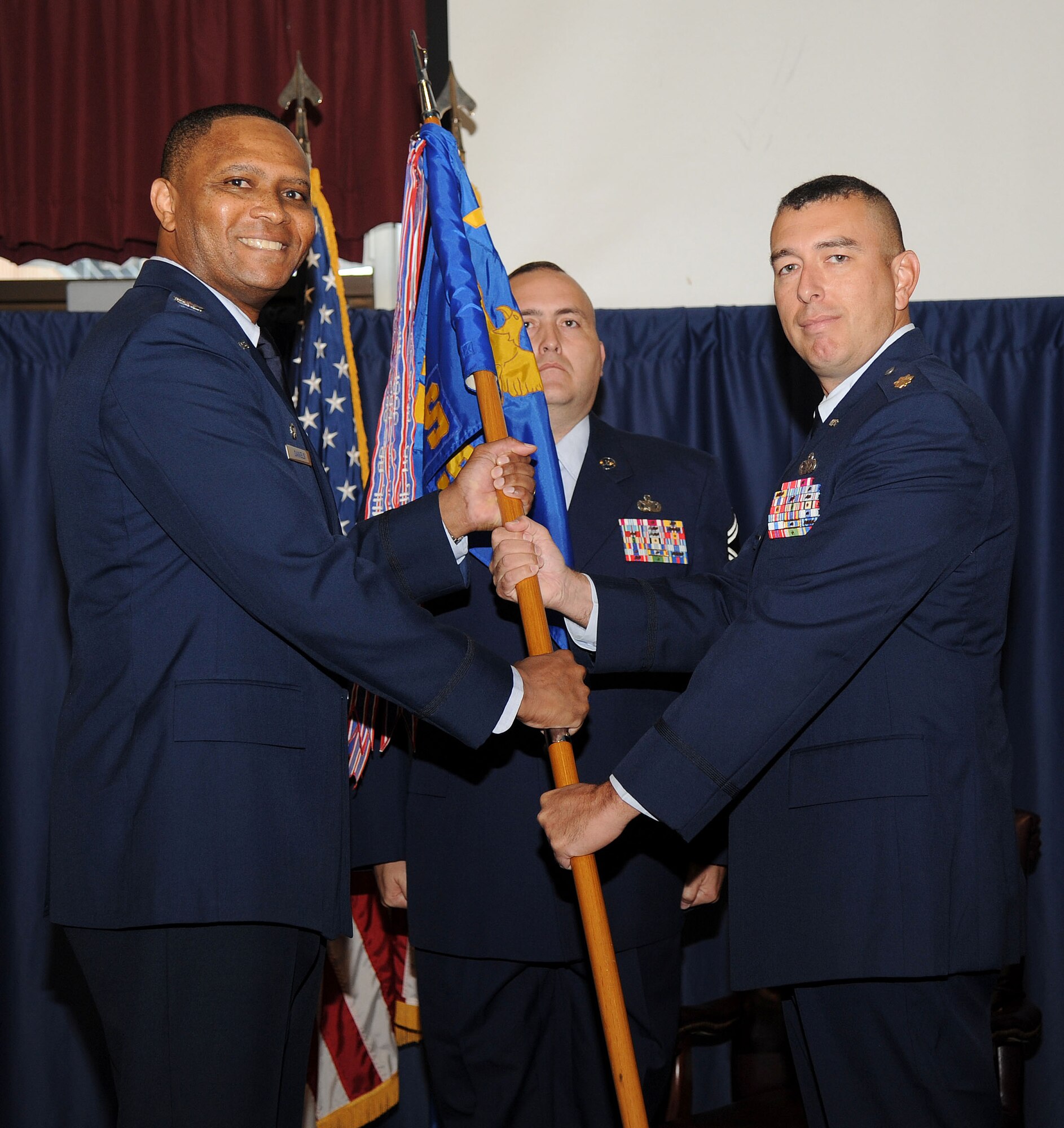 VANCE AIR FORCE BASE, Okla. -- Col. Christopher Daniels (left), the 71st Mission Support Group commander, passes the 71st Security Forces Squadron guidon to Maj. Thomas McGillicuddy during an assumption-of-command ceremony at the Vance Collocated Club. McGillicuddy was the commander of the 387th Expeditionary Security Forces Squadron, Ali Al Mubarak Air Base, Kuwait, before joining Team Vance. (U.S. Air Force Photo/Staff Sgt. Nancy Falcon)