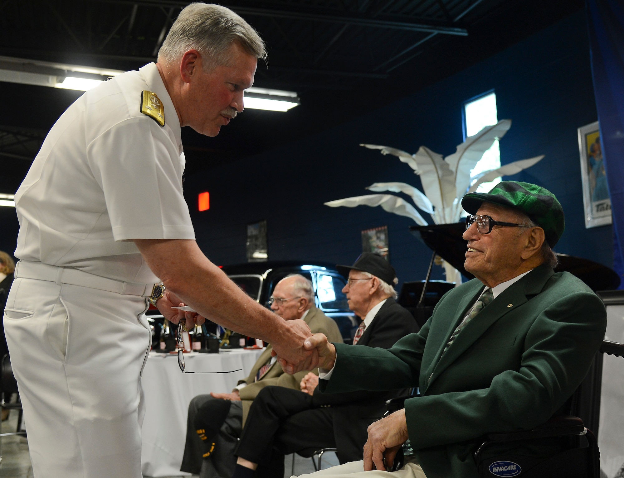 Vice Adm. Mark Fox, U.S. Central Command deputy commander, shakes the hand of former Army Pfc. Philip Melici, French Legion D’Honneur recipient, at a French National Day celebration in Tampa, Florida, July 14, 2014. Melici served for 23 months in England, France, Belgium and Holland as a pipeline patrolman during World War II. (U.S. Air Force photo by Airman 1st Class Ned T. Johnston/Released)