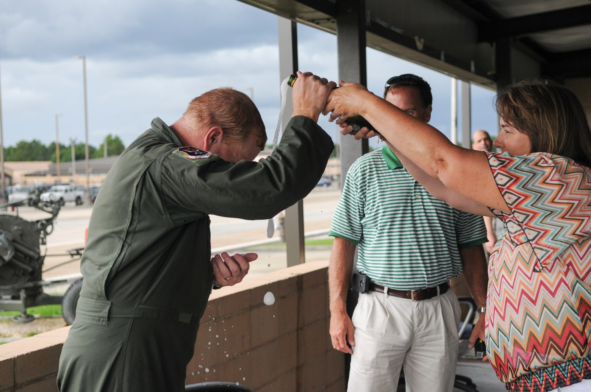 Anne Ramer, wife of U.S. Air Force Col. Steve Ramer, 23d Wing vice commander, showers him with champagne during his fini flight celebration, July 15, 2014 at Moody Air Force Base, Ga. Ramer has been the 23d vice commander since May 2012. (U.S. Air Force photo by Andrea Jenkins/Released) 