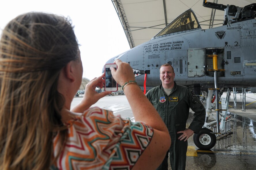 Anne Ramer takes a picture of her husband, U.S. Air Force Col. Steve Ramer, 23d Wing vice commander, next to his flagship A-10C Thunderbolt II during his fini flight celebration, July 15, 2014 at Moody Air Force Base, Ga. Ramer is heading to Osan Air Base, Republic of Korea. (U.S. Air Force photo by Andrea Jenkins/Released) 