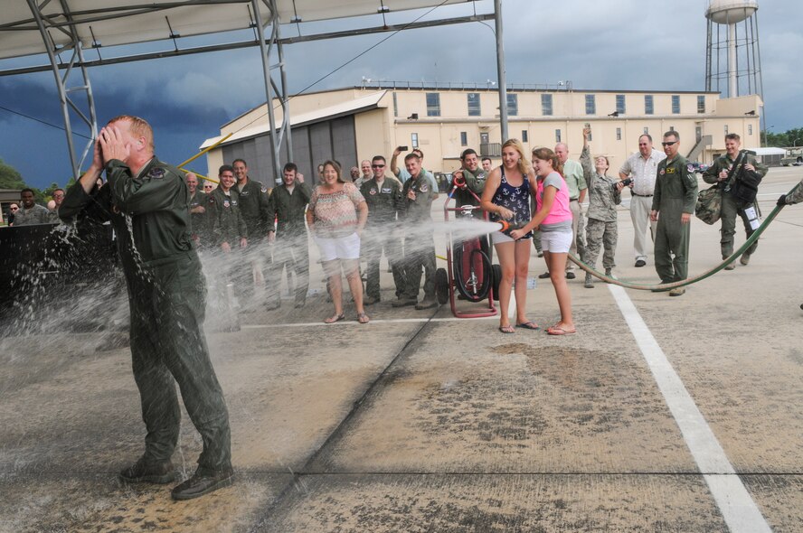 U.S. Air Force Col. Steve Ramer, 23d Wing vice commander, is hosed down by his two daughters during his fini flight celebration, July 15, 2014 at Moody Air Force Base, Ga. Ramer is an A-10C Thunderbolt II command pilot with more than 3,200 flying hours.  (U.S. Air Force photo by Andrea Jenkins/Released) 