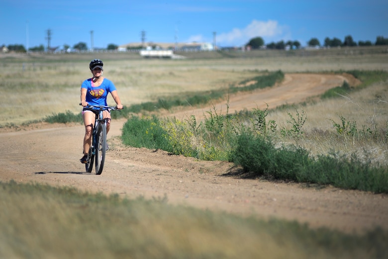 Danielle Hoddy, 50th Operations Support Squadron, bikes on the trail July 11, 2014, at Schriever Air Force Base, Colo., as part of the 4-Fit Challenge. Members of the 4th Space Operations Squadron challenged other Schriever squadrons for a day of sports and competition. (U.S. Air Force photo/Dennis Rogers)