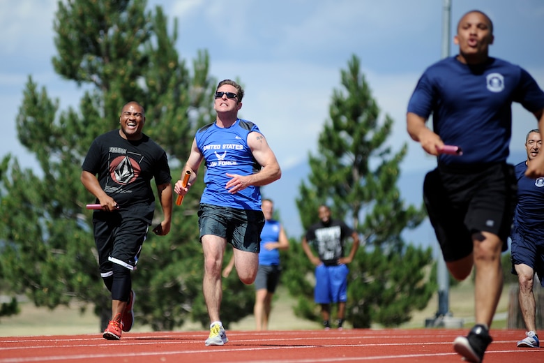 Participants race to the finish line during the 4X100 meter relay July 11, 2014, at Schriever Air Force Base, Colo., as part of the 4-Fit Challenge. The 4-Fit Challenge events includeed flag football, team pushup relay, 4X100 meter relay, 4X400-meter relay, pull-up contest, obstacle course relay, bench press contest and bike relay. (U.S. Air Force photo/Dennis Rogers)
