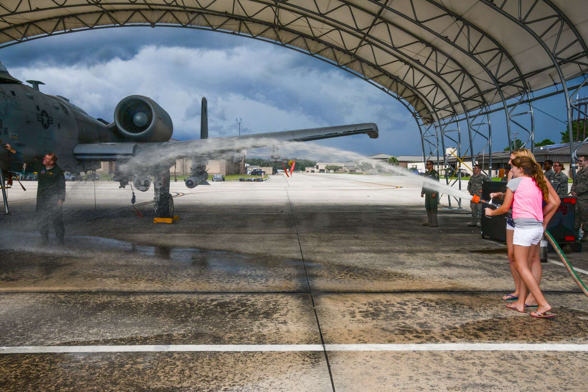 Alexis and Kristen Ramer spray their father, U.S. Air Force Col. Steve Ramer, with a fire hose following his final flight at Moody Air Force Base, Ga., July 15, 2014. As vice commander, Ramer oversaw 6,000 military and civilian personnel at Moody and its geographically separated units. (U.S. Air Force photo by Airman 1st Class Sandra Marrero/ Released)
