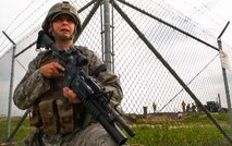 Airman 1st Class Hunter Snowman, 91st Missile Security Forces Squadron response force member, guards the outer perimeter of a launch facility during a training exercise in North Dakota, July 11, 2014. The exercise is to evaluate the response of infield forces to an attack at a simulated breached site. (U.S. Air Force photo/Senior Airman Brittany Y. Bateman)