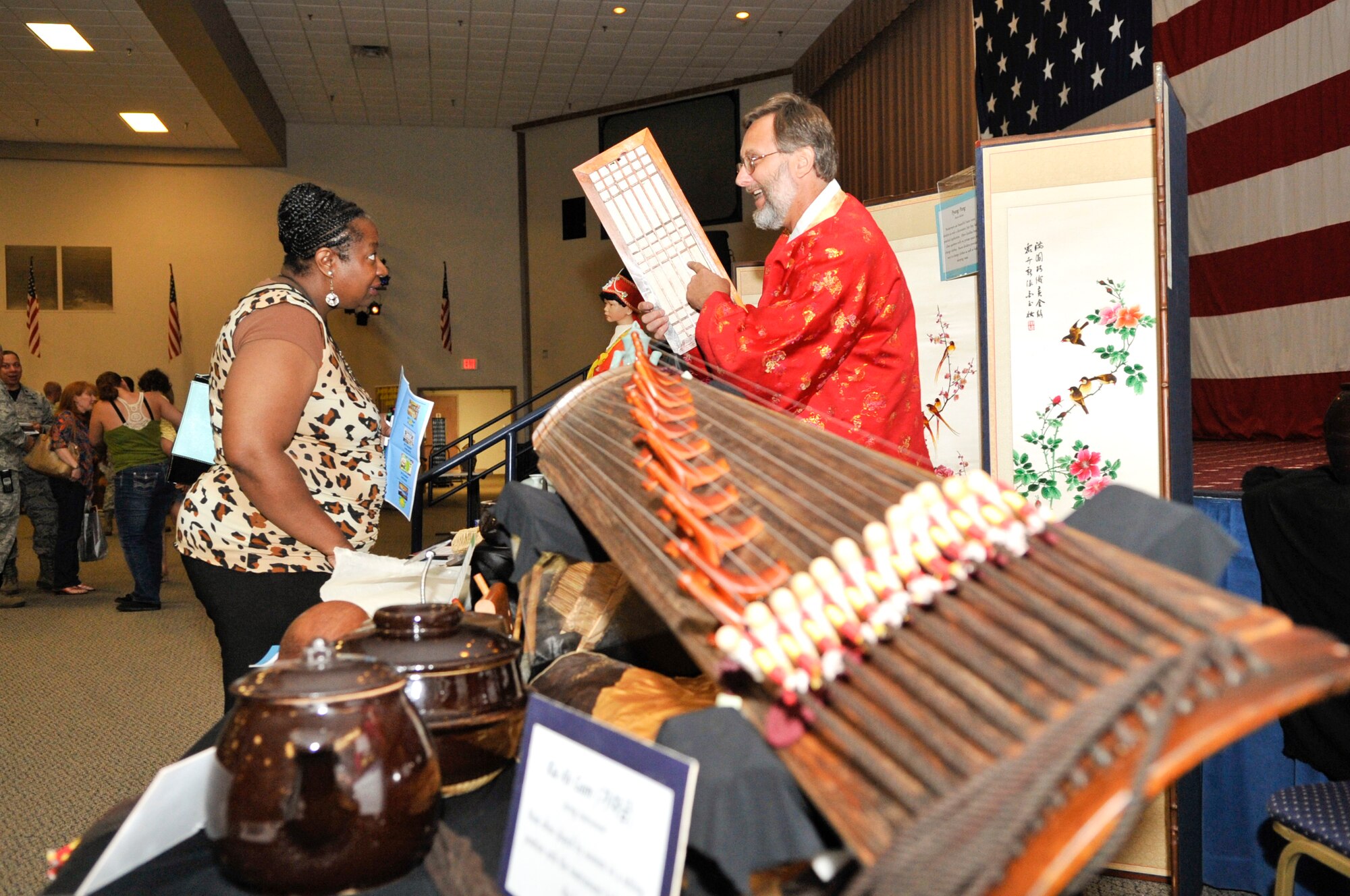 Robert Hasson, 608th Air Communications Squadron engineer technology services, talks to a visitor about common traditional Korean materials at the Sixth Annual Multicultural Day celebration on Barksdale Air Force Base, La., July 11, 2014. Also on display were dolls, pots, instruments and art. (U.S. Air Force photo/Airman 1st Class Benjamin Raughton)