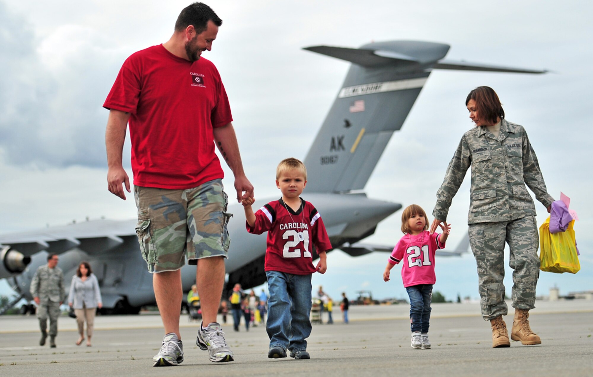 JOINT BASE ELMENDORF-RICHARDSON, Alaska -- J.R. Richarson, left,of Mullins, S.C., Trey Richardson, 4, Madisyn Richardson, 2, and Tech Sgt. Lucy Richardson, 176th Wing, of Bethel, Alaska, walk on the tarmac during the Operation: Arctic Warrior event for children and families at the Joint Mobility Complex, Saturday, Aug. 13, 2011.  Childden and families members of service personnel experienced a mock deployment, static displays and enjoyed lunch during the event.  (U.S. Air Force/Justin Connaher).