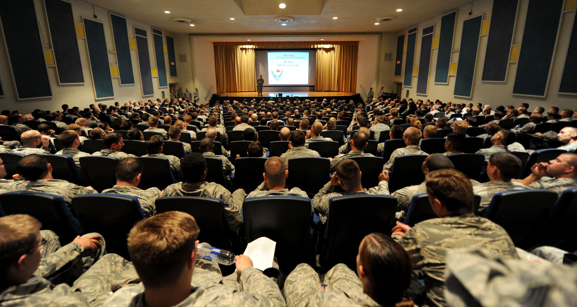Lt. Col. Joseph Shirey, 28th Maintenance Group deputy commander, greets Red Flag 14-3 participants during a welcome brief inside the base theater at Nellis Air Force Base, Nev., July 13, 2014. This exercise is comprised of 16 squadrons, 2 coalition partners and more than 100 aircraft and 2,400 personnel. (U.S. Air Force photo by Tech. Sgt. Jerry Fleshman/Released)