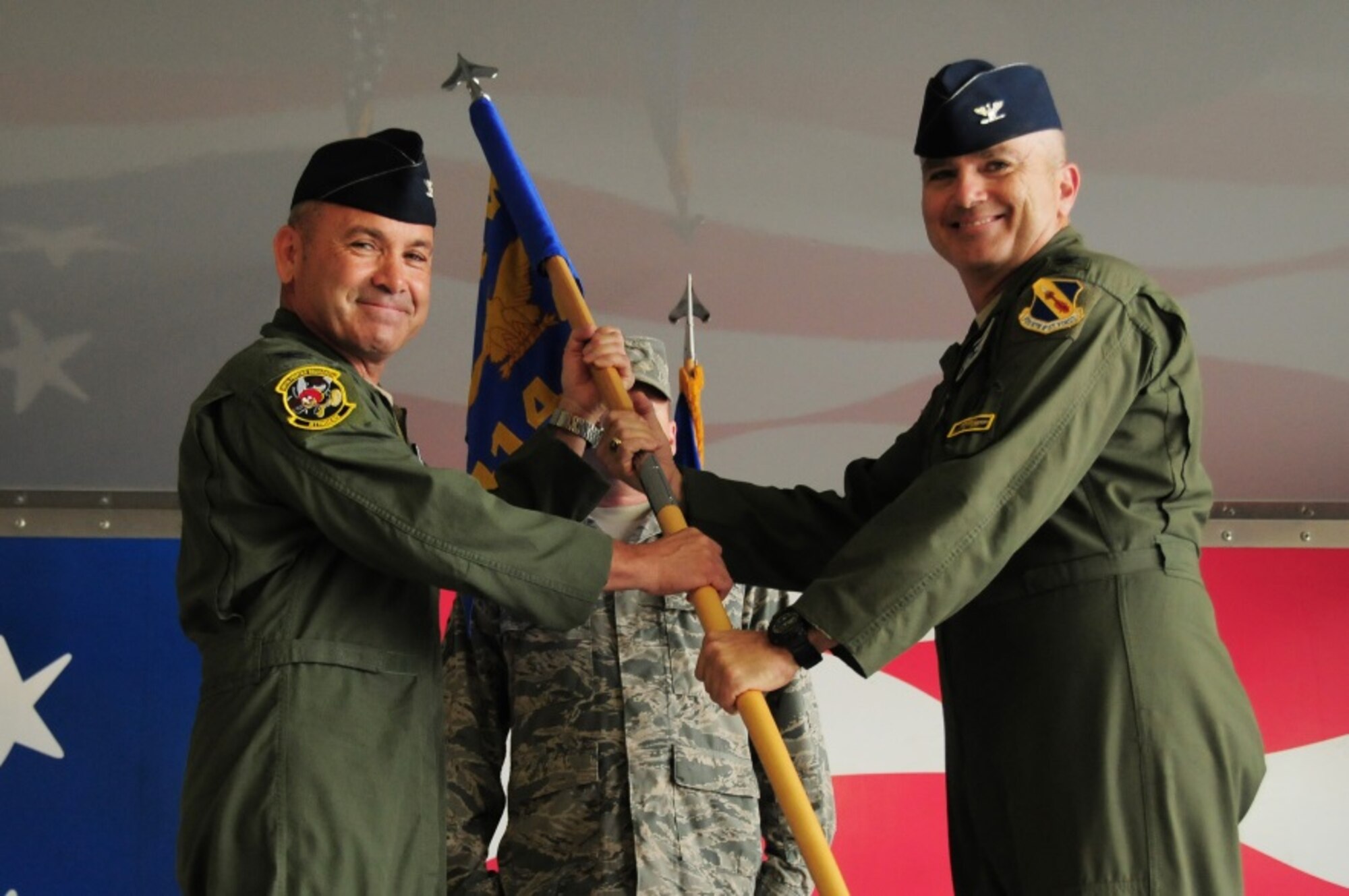 Col. Christopher Freeman, incoming 414th Fighter Group commander, receives the 414th FG guidon from Col. Kurt Gallegos, 944th Fighter Wing commander, during a change of command ceremony held at Seymour Johnson Air Force Base July 11, 2014. Freeman assumed command of the 414th FG after serving as the 414th Maintenance Squadron commander. (U.S. Air Force photo by Staff Sgt. Lausanne Kinder)