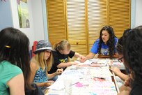 Kayla McKenney (right), Youth Program Staff volunteer, gives assistance to Juliette Gerst (left) and Alex Gerst in an art class July 9 during the Joint Base San Antonio 2014 Military & Family Readiness Arts and Dance Camp at JBSA-Randolph. (U.S. Air Force photo by Melissa Peterson)