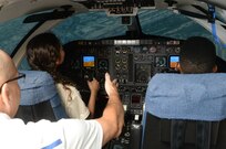 Michael Mullen (left), 12th Operations Support Squadron flight simulator instructor, teaches San Antonio Aviation Career Education Camp students Lorena Longoria (center) and Derek Cox (right), what it is like to fly in a simulator July 8 during a field trip to the 99th Flying Training Squadron at Joint Base San Antonio-Randolph. The ACE Camp offers young people ages 14-17 an opportunity to explore the many career options available in the aviation industry. (U.S. Air Force photo by Johnny Saldivar)