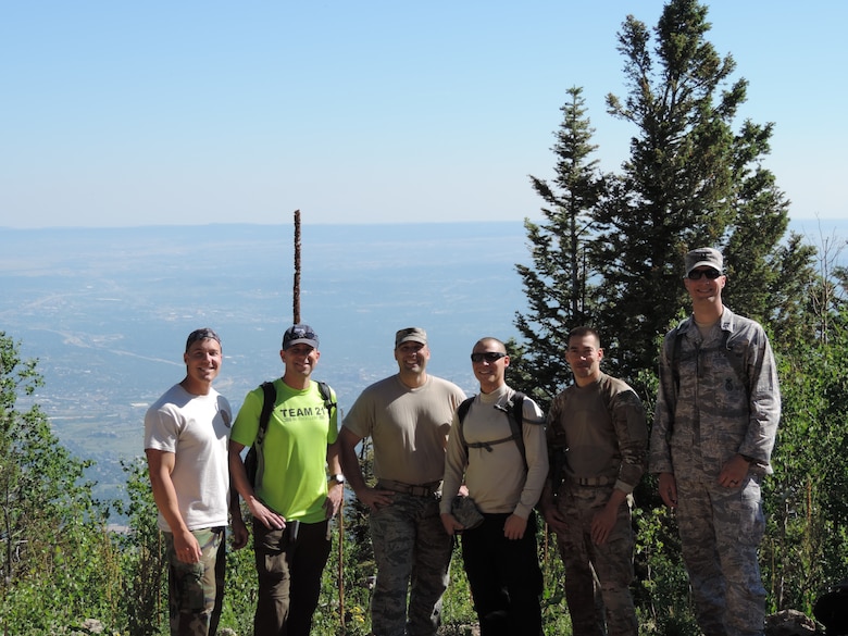 CHEYENNE MOUNTAIN AIR FORCE STATION, Colo. – Col. John Shaw (second from left), 21st Space Wing commander, accompanies 721st Security Forces Squadron Airmen on a hike to the peak of Cheyenne Mountain July 3. The journey from CMAFS' lower parking lot to the peak includes a climb of more than 2,400 feet to 9,400 feet above sea level. The group had to blaze their own trail to the top during the hike as no trail exists. Pictured (left to right) are Staff Sgt. Brent Gilley, Shaw, Maj. James Serra, Staff Sgt. Adam Zelenka, Master Sgt. Joseph Sanchez and Capt. Matthew McGinnis. (U.S. Air Force photo)