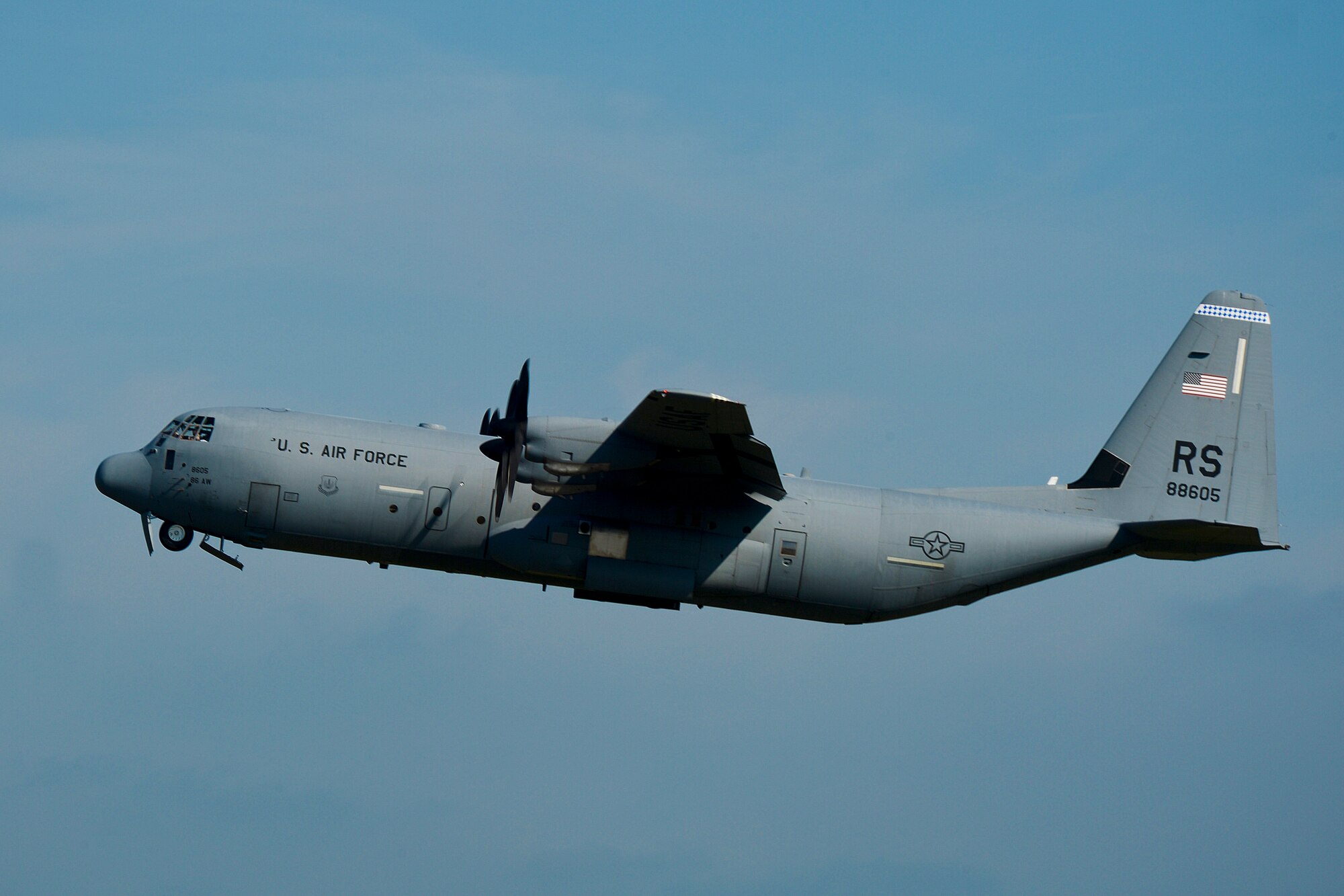 A C-130 Hercules flies through the air as Airmen assigned to the 48th Security Forces Squadron depart from Royal Air Force Lakenheath, July 16, 2014. The Airmen deployed to Djibouti to provide security and protection to Air Force assets. (U.S. Air Force photo by Airman 1st Class Trevor T. McBride/Released)