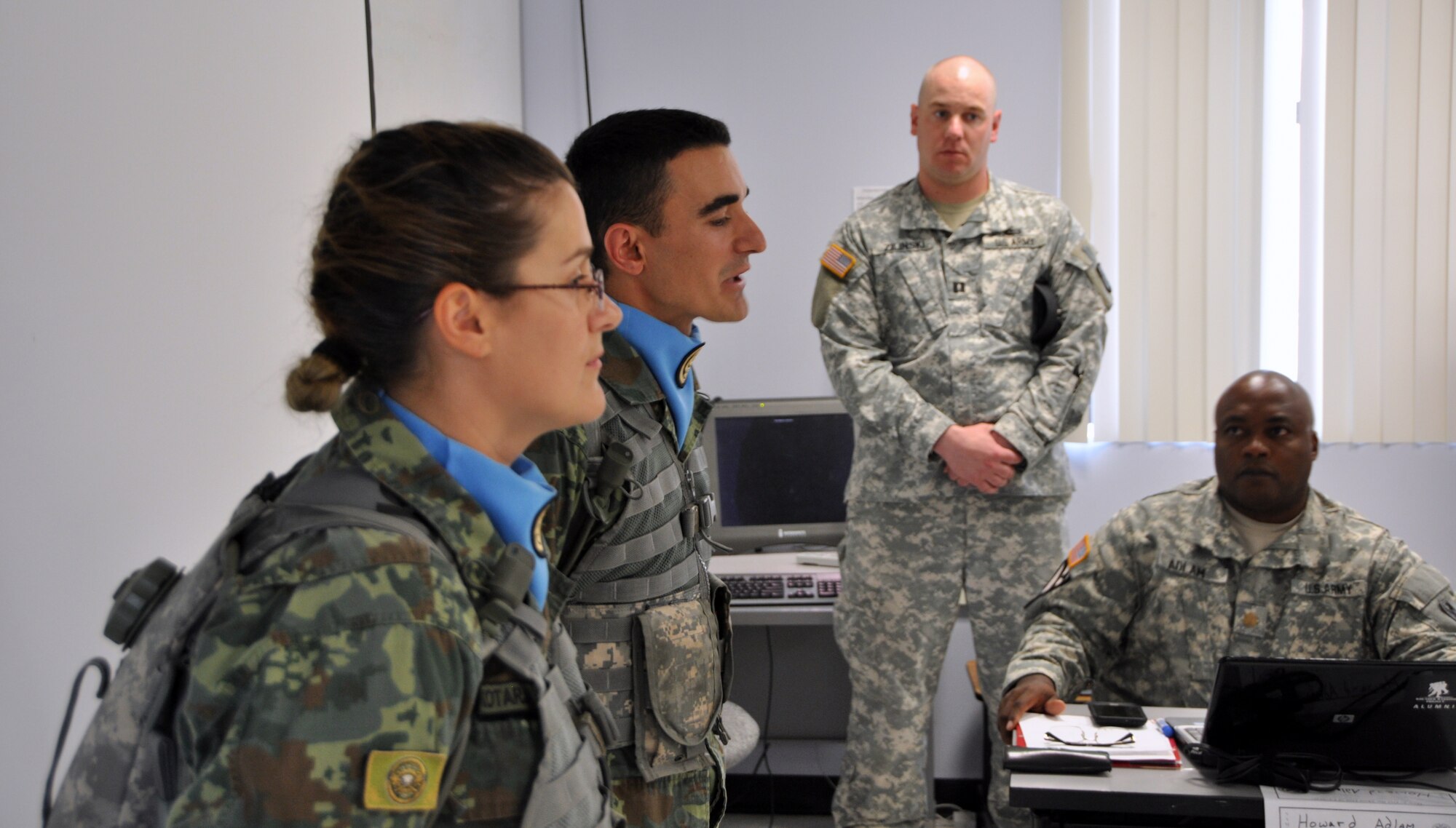 Albanian 2nd Lt. Hekuran Budani and Sgt. Marjana Kotarja speak to students of the Command and General Staff Officer Course at Joint Base Dix-McGuire-Lakehurst, N.J., about the first-of-its-kind Officer Candidate School they are attending. In the background is Matthew Zilinski, senior platoon training officer of New Jersey's OCS program for the Albanians. (U.S. Army photo by Staff Sgt. Bert Crespo/Released)