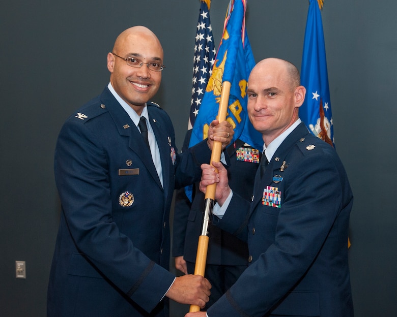 PETERSON AIR FORCE BASE, Colorado – Col. David Miller Jr. (left), 21st Operations Group commander, passes the 4th Space Control Squadron guidon to Lt. Col. Eric Lingle, 4th SPCS commander, during the squadron’s change of command ceremony here July 11. Lingle assumed command of the 4th SPCS, which provides combat space superiority effects to the commander, Joint Functional Component Command – Space and theater combatant commanders. (U.S. Air Force photo/Craig Denton)