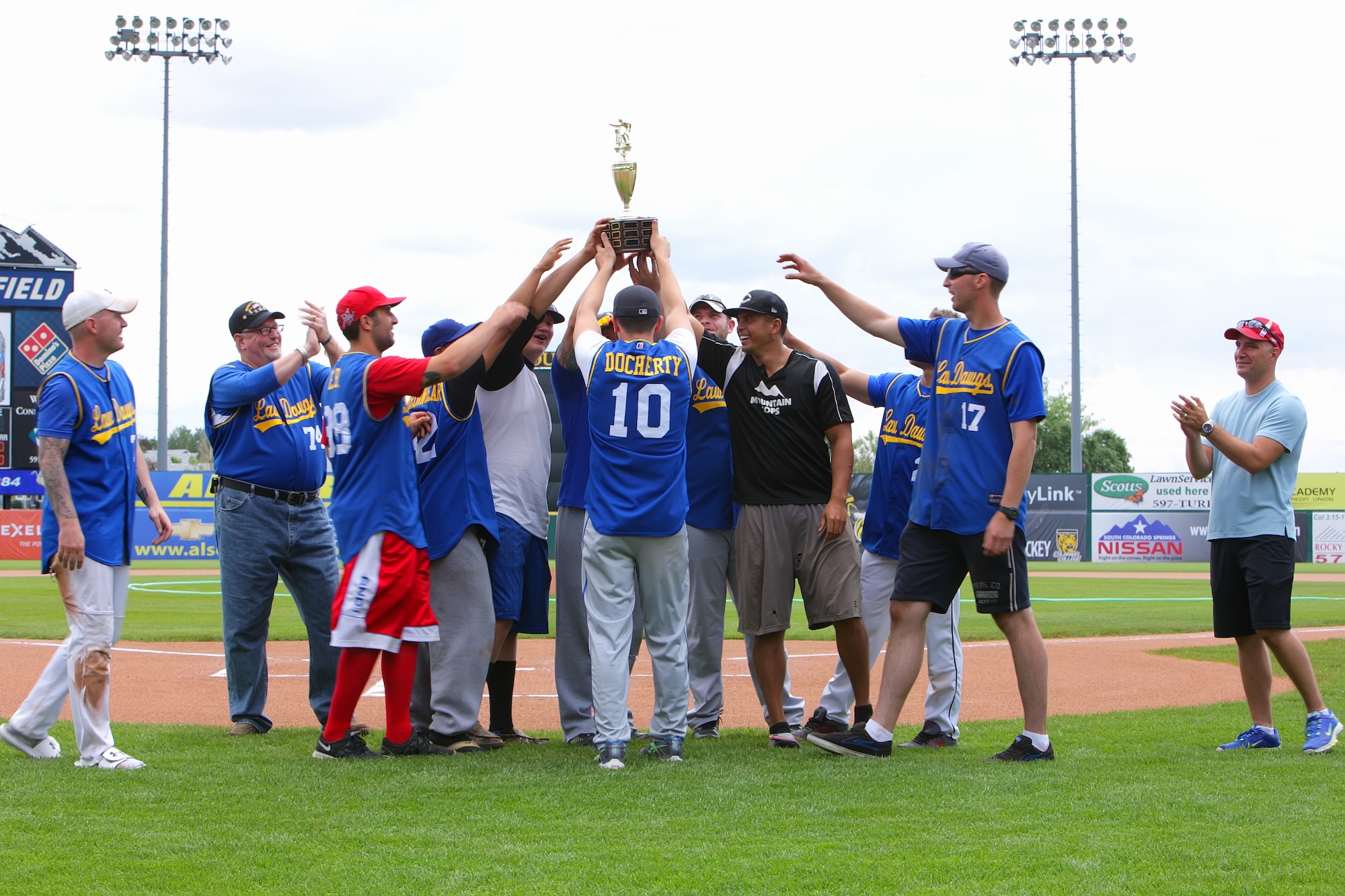 COLORADO SPRINGS, Colo. — The 721st Security Forces Squadron hoists its 2014 Guns and Hoses charity slow-pitch softball tournament championship trophy after its win over the 21st Civil Engineer Squadron Fire Department at Skysox Stadium July 13. In its fifth year, the Skysox-sponsored tournament brought together local civilian and military police and firefighters to promote camaraderie and raise money for charity. This year, the tournament raised $500 for the ‘Love A Hero’ charity, which honors firefighters, military and law enforcement officers. (U.S. Air Force photo/Col.Travis Harsha)