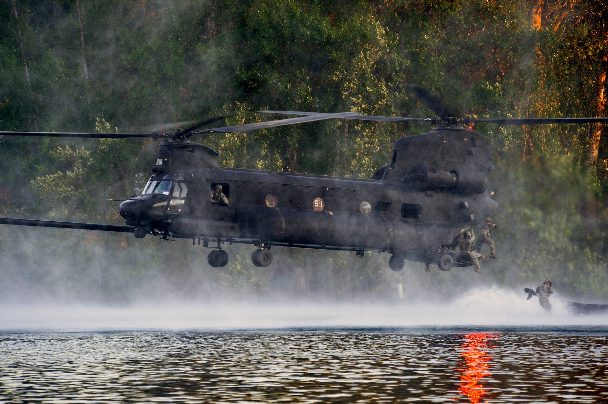 Airmen from the 22nd Special Tactics Squadron’s Red Team jump out of an MH-47 Chinook helicopter July 14, 2014, during helocast alternate insertion and extraction training with Soldiers from the 160th Special Operations Aviation Regiment at American Lake on Joint Base Lewis-McChord, Wash. This exercise proved that Soldiers and Airmen from Joint Base Lewis-McChord can train together, fight together and run a base together. (U.S. Air Force photo/Staff Sgt.Russ Jackson)
