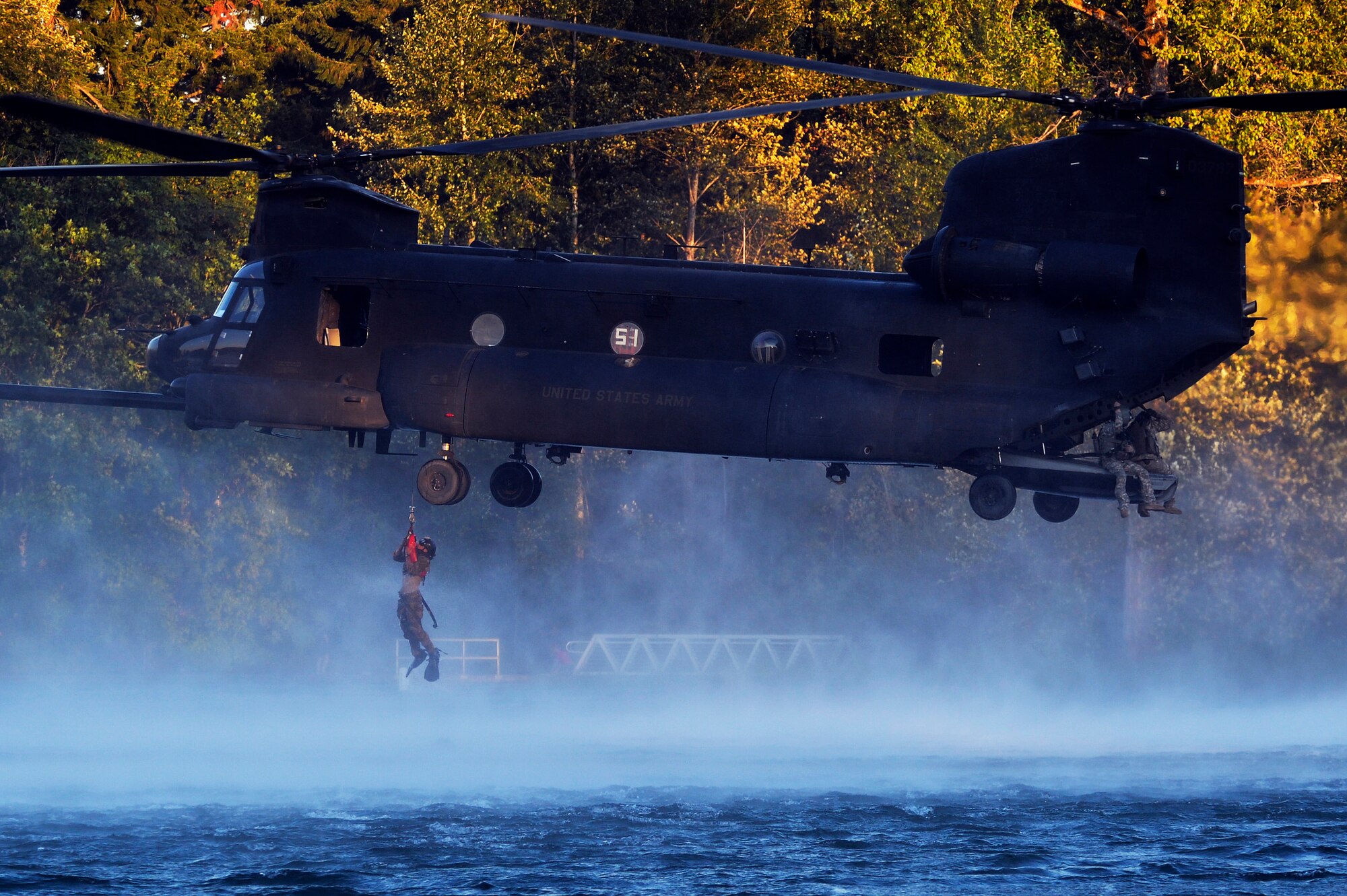 An Airman from the 22nd Special Tactics Squadron’s Red Team is hoisted up to an MH-47 Chinook helicopter July 14, 2014, during helocast alternate insertion and extraction training with Soldiers from the 160th Special Operations Aviation Regiment at American Lake on Joint Base Lewis-McChord, Wash. The 22nd STS Airmen took part in joint operations with the 160th SOAR assisting their Soldiers in upgrade helocast and hoist training. (U.S. Air Force photo/Staff Sgt.Russ Jackson)
