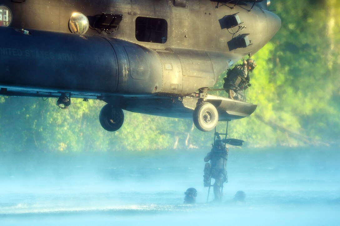 An Airman from the 22nd Special Tactics Squadron’s Red Team climbs a rope ladder July 14, 2014, into an MH-47 Chinook helicopter during helocast alternate insertion and extraction training with Soldiers from the 160th Special Operations Aviation Regiment at Joint Base Lewis-McChord, Wash. The daytime training allowed five Airmen to climb a rope ladder and three Airmen to be hoisted back into the MH-47. (U.S. Air Force photo/Staff Sgt.Russ Jackson)