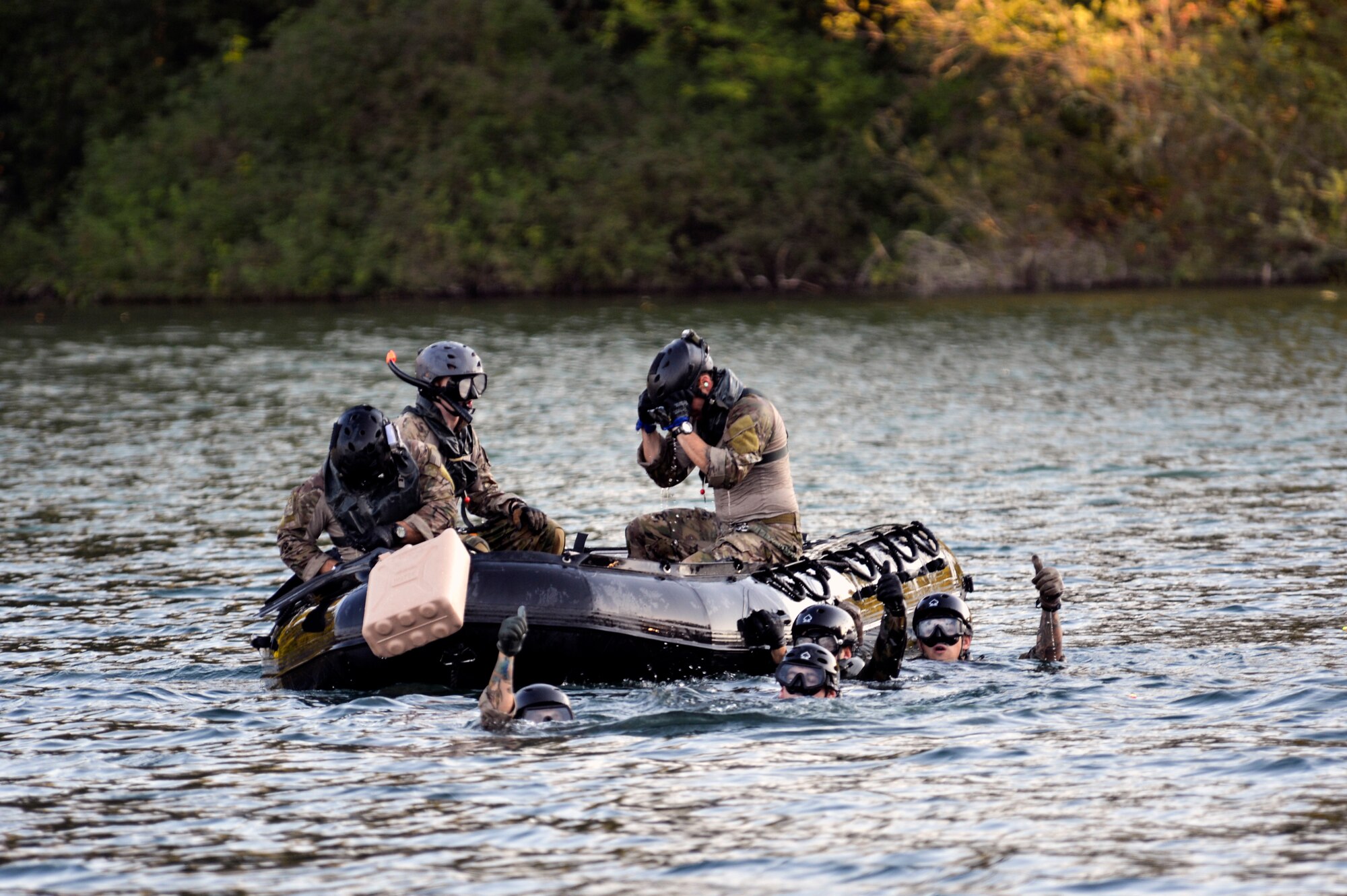 Airmen from the 22nd Special Tactics Squadron’s Red Team give Soldiers in an MH-47 Chinook helicopter the thumbs up July 14, 2014, to let them know they were fully accounted for in the water of American Lake on Joint Base Lewis-McChord, Wash. The Airmen practiced soft duck operations which involve them pushing an inflated zodiac boat out of the back of the helicopter as they jump in after it. (U.S. Air Force photo/Staff Sgt.Russ Jackson)