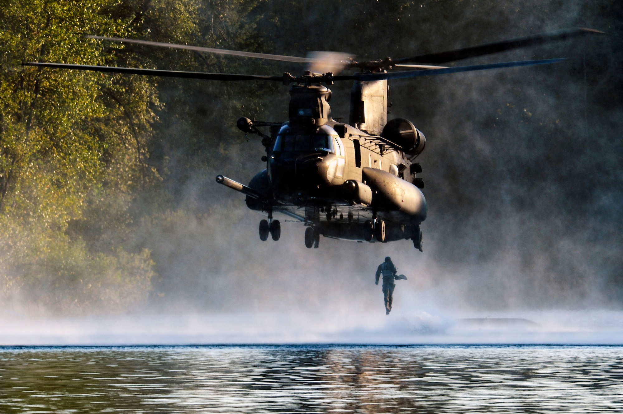 An Airman from the 22nd Special Tactics Squadron’s Red Team jumps out of an MH-47 Chinook helicopter July 14, 2014, during helocast alternate insertion and extraction training with Soldiers from the 160th Special Operations Aviation Regiment at American Lake on Joint Base Lewis-McChord, Wash. Helocasting is an airborne technique used by special operations forces units for amphibious insertion into a military area of operation. (U.S. Air Force photo/Staff Sgt.Russ Jackson)