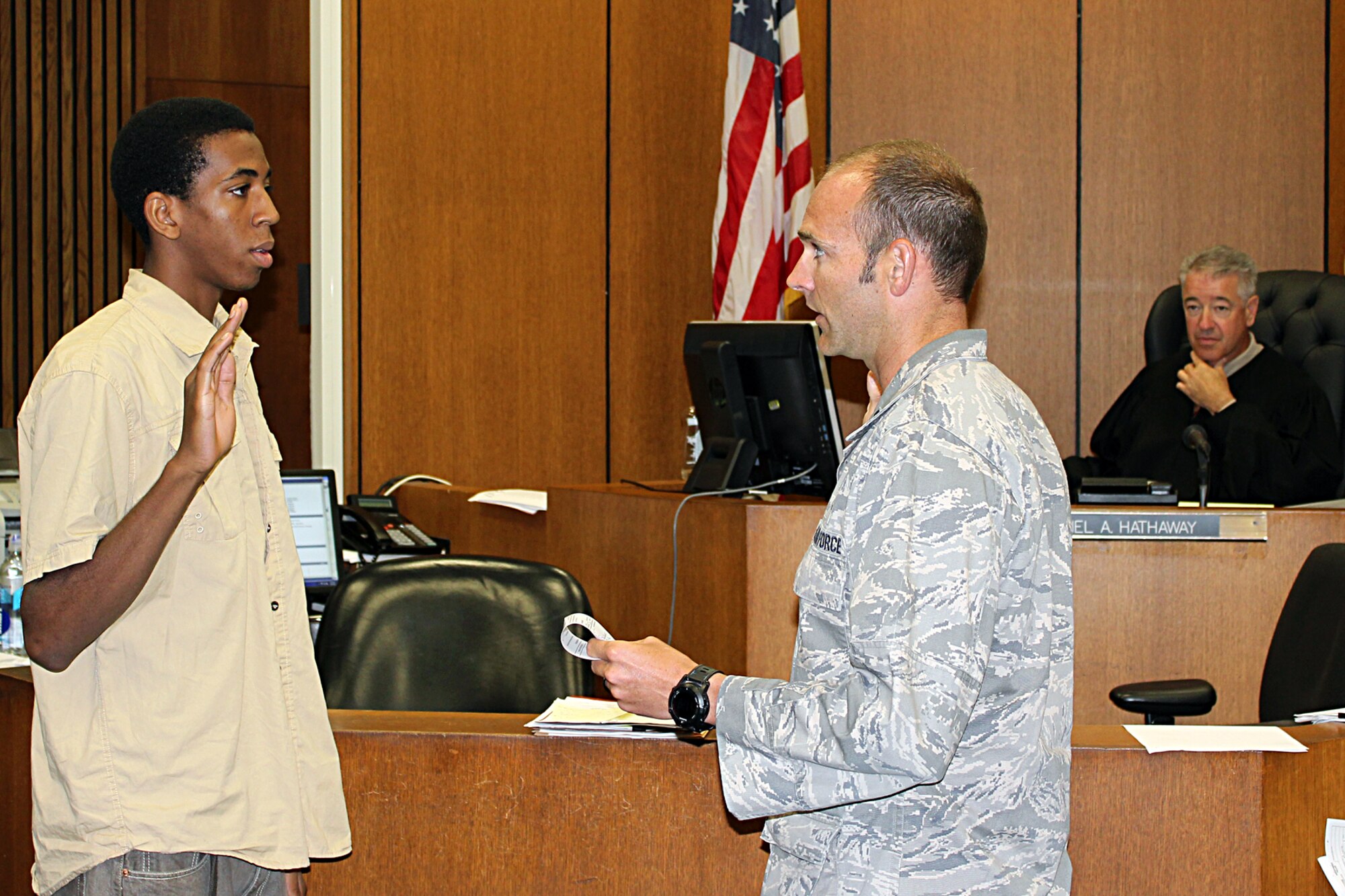 Torrey Gray is sworn in as a new recruit in the Michigan Air National Guard by 1st Lt. Robert McLean in the courtroom of Circuit Court Judge Daniel Hathaway in Detroit, July 15, 2014. Gray was sworn in at the court so that his mother, Tonya Gray, a Wayne County Sheriff’s deputy who works at the court, could watch her son take the oath of office. Tonya Gray is also a member of the Michigan Army National Guard. McLean is the commander of the 107th Weather Flight at Selfridge Air National Guard Base, Mich., where Torrey Gray will serve as a member of the 127th Force Support Squadron. (U.S. Air National Guard photo by Tech. Sgt. Dan Heaton)
