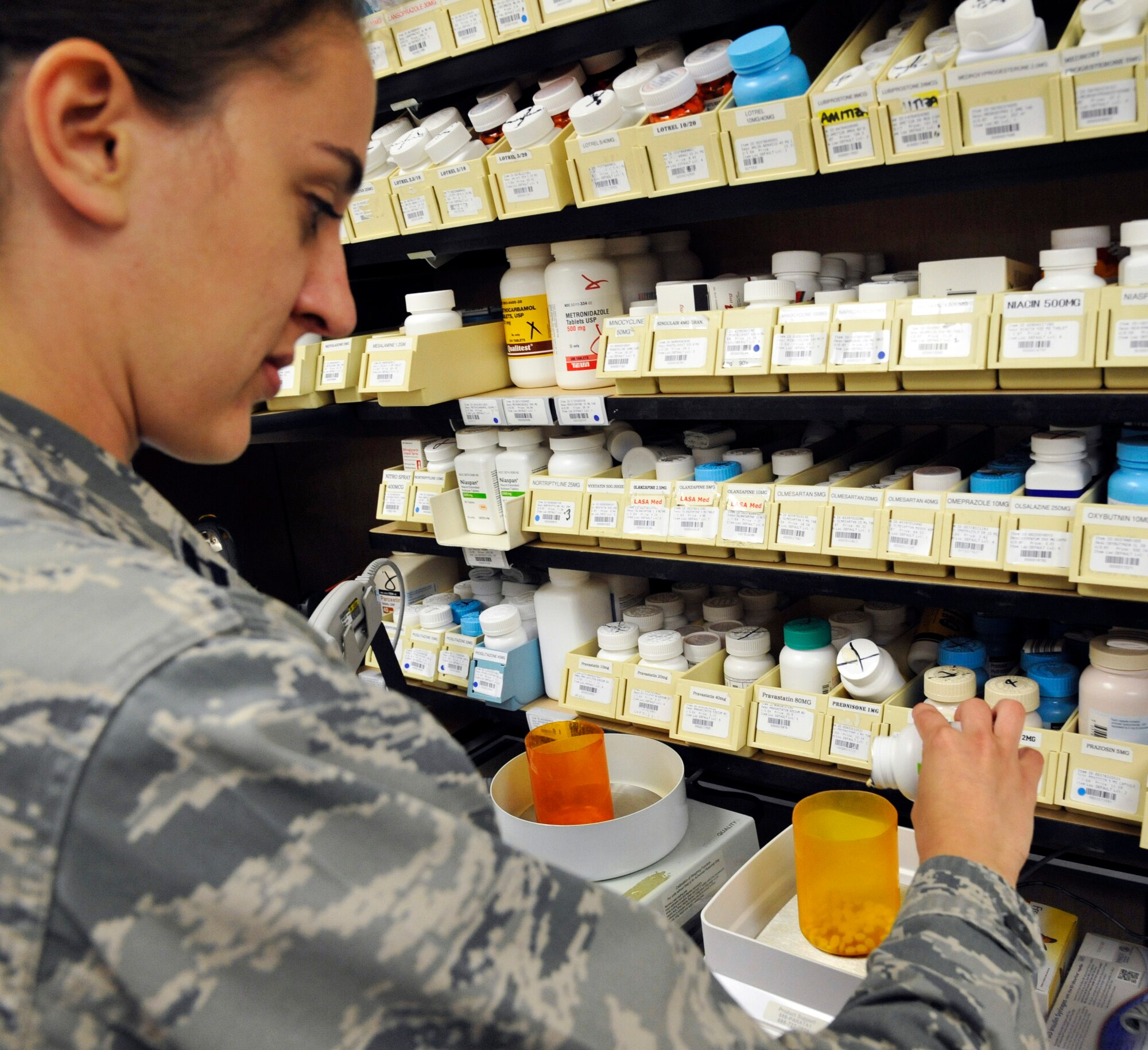 U.S. Air Force Capt. Rachel Casey, 509th Medical Support Squadron pharmacist, weighs medication at Whiteman Air Force Base, Mo., June 18, 2014. This process is used to obtain an accurate pill count and integrate technology into daily operations to streamline the filling process. (U.S. Air Force photo by Airman 1st Class Keenan Berry/Released)